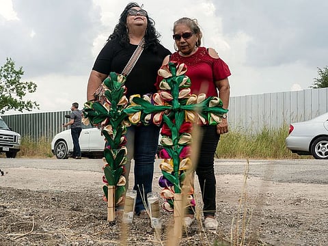 Local community members Debra Ponce, left, and  Angelita Olvera mourn after they placed crosses and candles at the scene  where dozens of people were found dead inside a trailer truck in San Antonio, Texas, U.S. June 28, 2022. 
