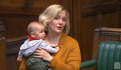 A video grab taken on June 30, 2022 from footage broadcast by the UK Parliament's Parliamentary Recording Unit (PRU) shows British Labour MP Stella Creasy speaking with her baby daughter in the chamber of the House of Commons in London on June 4, 2020.