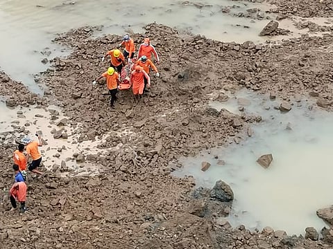 This photograph provided by India's National Disaster Response Force (NDRF) shows NDRF personnel carrying the body of a victim of a mudslide in Noney, northeastern Manipur state, India, Friday, July 1, 2022.