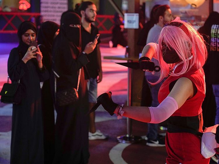 Saudi visitors film a woman dressed in Japanese anime during Jeddah Season at the City Walk, in Jeddah, Saudi Arabia, on June 30, 2022.  