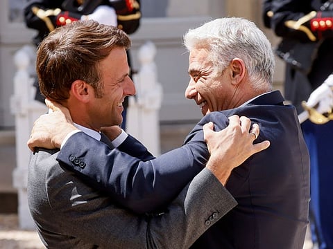 French President Emmanuel Macron, left, hugs Israel's Prime Minister Yair Lapid ON July 5, 2022 at the Elysee Palace in Paris.  