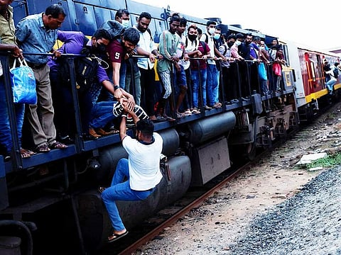 A passenger is helped by others to get to the engine compartment of an overcrowded train as other public transports are being disturbed due to major fuel shortage, amid the country's economic crisis, in Colombo, Sri Lanka, July 6, 2022. 