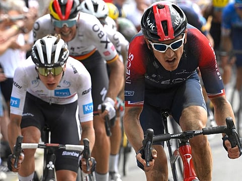 UAE Team Emirates team's Tadej Pogacar wearing the best young rider's white jersey (left) and Ineos Grenadiers team's British rider Geraint Thomas (right) cycle across a cobblestone sector in the final kilometers of the fifth stage of the 109th Tour de France on Wednesday.