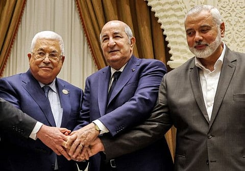 Palestinian president Mahmoud Abbas shaking hands with Algerian President Abdul Majid Tebboune and with Palestinian Hamas movement's leader Esmail Haniya during Abbas' visit to attend Algeria's 60th independence anniversary in the capital Algiers on July 5, 2022.. 