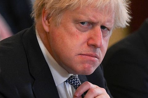 In this file photo taken on May 24, 2022 Britain's Prime Minister Boris Johnson adjusts his tie at the start of a cabinet meeting at 10 Downing Street in London.