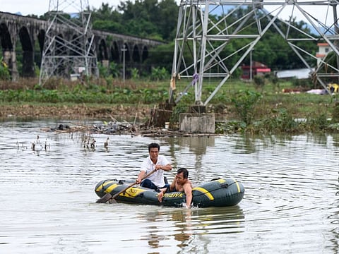 Residents ride a boat in a flooded area after heavy rains caused by typhoon Chaba, in Yingde, Qingyuan city, in China's southern Guangdong province on July 6, 2022.