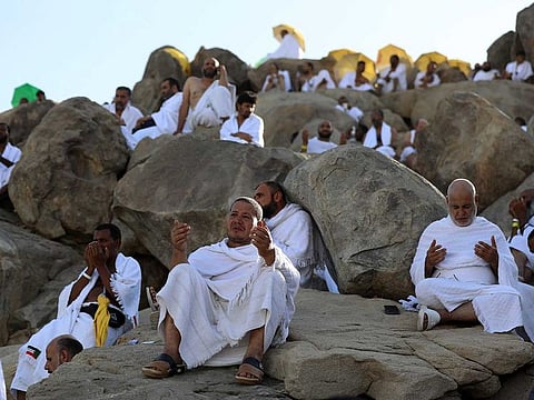Pilgrims pray atop Mount Arafat, also known as Jabal al-Rahma (Mount of Mercy), southeast of the Saudi holy city of Mecca, during the climax of the Hajj pilgrimage, early on July 8, 2022. 