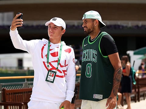 Nick Kyrgios obliges a selfie-seeking fan as he heads for practice at the Wimbledon.