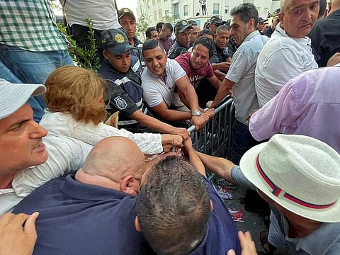 Supporters of Tunisia's Free Constitutional Party try to remove barricades as they attempt to reach the headquarters of the Independent High Authority for Elections, during a protest against the upcoming referendum on a new constitution, in Tunis, Tunisia  July 7, 2022.