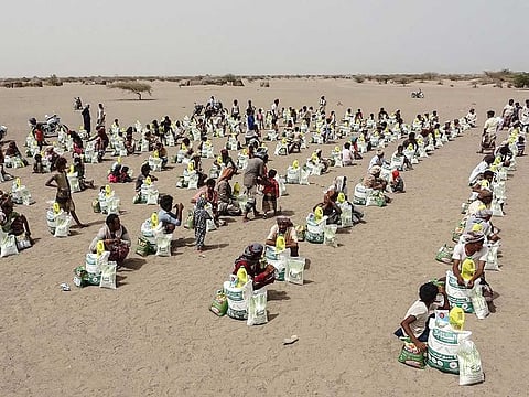 Yemenis displaced by the conflict, receive food aid and supplies to meet their basic needs, at a camp in Hays district in the war-ravaged western province of Hodeida,  on July 6, 2022. 