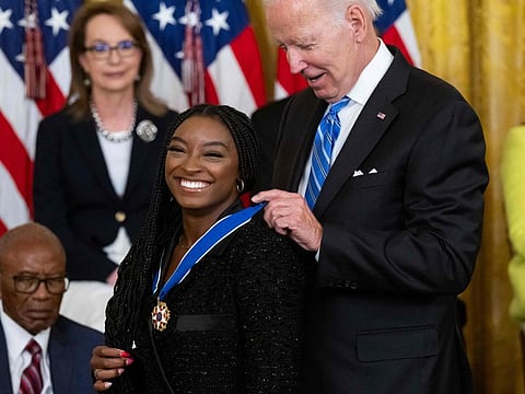 US President Joe Biden presents Gymnast Simone Biles with the Presidential Medal of Freedom, the nation's highest civilian honor, during a ceremony honoring 17 recipients, in the East Room of the White House in Washington, DC, July 7, 2022.