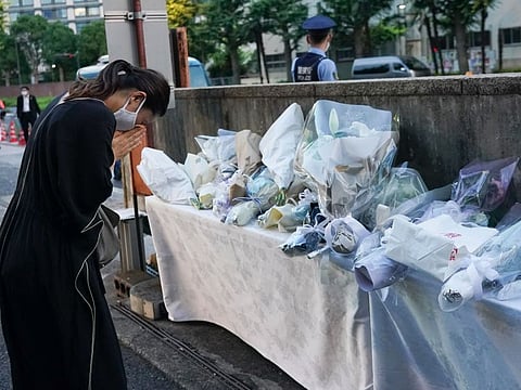 Mourners offer flowers at the entrance of the Liberal Democratic Party (LDP) headquarters building in Tokyo, on Sunday.