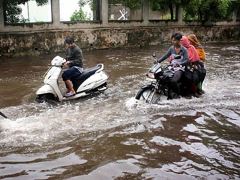 Commuters travel on a heavily waterlogged road after heavy rainfall, in Bhopal on Monday. 