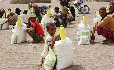 Yemenis displaced by the conflict, receive food aid and supplies to meet their basic needs, at a camp in Hays district in the war-ravaged western province of Hodeida,  on July 6, 2022. - In Yemen, millions have been forced from their homes in the brutal conflict pitting the Saudi-backed government against Iran-backed Huthi rebels, which has sparked widespread food shortages and ravaged the country's infrastructure. (Photo by Khaled Ziad / AFP)
