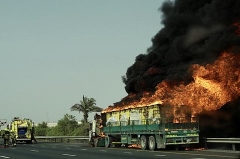 Fire fighters try to contain fire that engulfed a truck on E311 Mohamad bin Zayed Road, near Global Village, on Wednesday. 