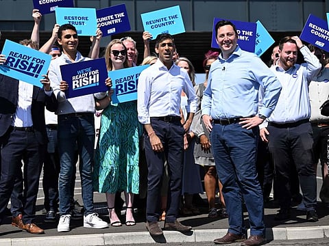 Conservative MP and Britain's former Chancellor of the Exchequer, Rishi Sunak (C) stands with Tees Valley Mayor Ben Houchen (R) and activists during a visit to Teesside Freeport in Redcar, north east England on July 16, 2022, as part of his bid to become the next leader of the Conservative party. 