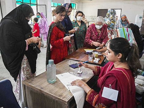 Voters arrive to cast their ballot at a polling station during the by-election in Punjab province assembly seat in Lahore on July 17, 2022.