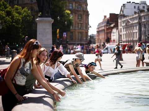 People cool off in a water fountain during a heatwave, at Trafalgar Square in London, Britain, July 19, 2022