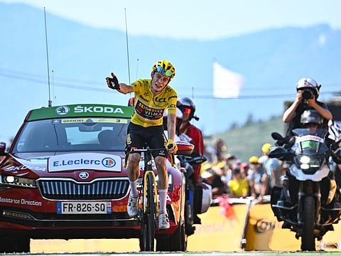 Jumbo-Visma team's Danish rider Jonas Vingegaard wearing the overall leader's yellow jersey celebrates as he crosses the finish line to win Stage 18 of Tour de France on Thursday.