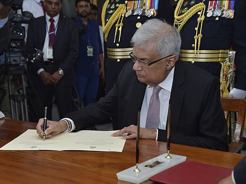 In this photo provided by Sri Lankan President's Office, Sri Lanka's newly elected president Ranil Wickremesinghe, signs after taking oath during his swearing in ceremony in Colombo, Sri Lanka, Thursday, July 21, 2022.