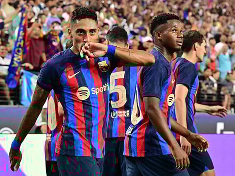 Barcelona's Raphinha celebrates with teammates after scoring during the friendly match against Real Madrid at Allegiant Stadium in Las Vegas, Nevada.
