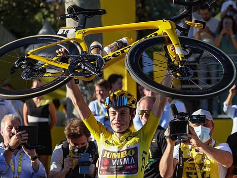 Jumbo-Visma team's Danish rider Jonas Vingegaard wearing the overall leader's yellow jersey raises his bicycle as he celebrates winning the 109th edition of the Tour de France cycling race, after the 21st and final stage, 115,6 km between La Defense Arena in Nanterre, outside Paris, and the Champs-Elysees in Paris, France.