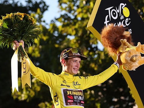 Jumbo-Visma team's Danish rider Jonas Vingegaard celebrates on the podium with the overall leader's yellow jersey after winning the 109th edition of the Tour de France cycling race, after the 21st and final 115,6 km stage between La Defense Arena in Nanterre, outside Paris, and the Champs-Elysees in Paris, France.