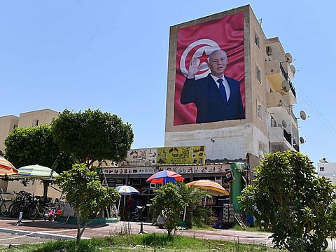 A billboard depicting Tunisia's Kais Saied hangs on the side of a building in the east-central city of Kairouan, on July 26, 2022. 