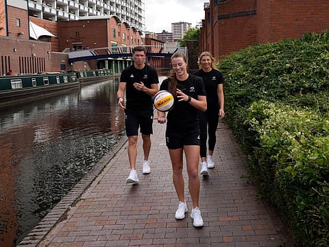 Members of New Zealand beach volley ball team walk by a canal near the Commonwealth Games arena in Birmingham, England, Tuesday, July 26, 2022. (AP Photo/Manish Swarup)