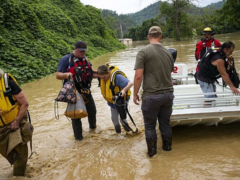 Members of a rescue team assist a family out of a boat on July 28, 2022 in Quicksand, Kentucky. 