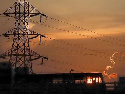 A silhouette of a public transport passing a brigde during the sunset, in Chennai. 