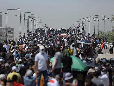 Protesters gather on a bridge leading to the Green Zone area in Baghdad, Iraq, Saturday, July 30, 2022. 