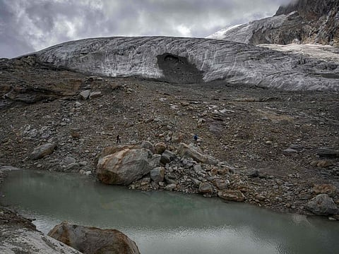 Tourists are seen next to the Fee Glacier (German: Feegletscher) above the Swiss alpine resort of Saas-Fee on July 30, 2022. Little snow cover and glaciers melting at an alarming rate amid Europe's sweltering heatwaves have put some of the most classic Alpine hiking routes off-limits.