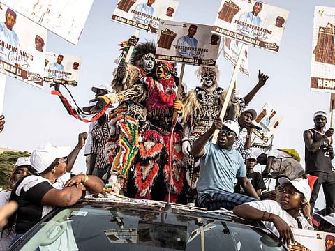 Supporters of the coalition of the President of Senegal Macky Sall, Bennoo Bokk Yaakaar, carry placards of their candidates during their final campaign rally in Dakar on July 29, 2022.