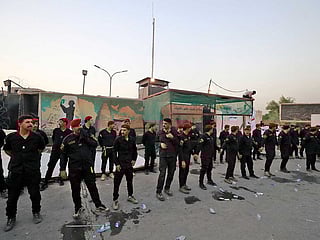 Members of Iraq's former paramilitary alliance Hashed Al Shaabi stand guard as supporters of the Coordination Framework take part in a counter-protest against Sadr's loyalists who have been occupying the parliament, outside the capital Baghdad's high-security Green Zone on August 1, 2022. 