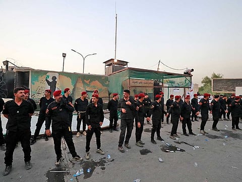 Members of Iraq's former paramilitary alliance Hashed Al Shaabi stand guard as supporters of the Coordination Framework take part in a counter-protest against Sadr's loyalists who have been occupying the parliament, outside the capital Baghdad's high-security Green Zone on August 1, 2022. 