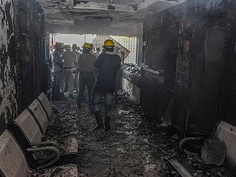 First responders inspect a burnt-out a hospital after a fire broke out in Jabalpur on August 1, 2022.