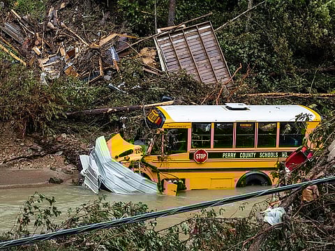 A Perry County school bus, along with other debris, sits in a creek near Jackson, Kentucky, on July 31, 2022. 