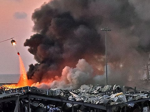 In this file photo taken on August 04, 2020 a helicopter puts out a fire at the scene of an explosion at the port of Lebanon's capital Beirut.  
