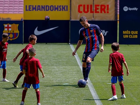 Polish forward Robert Lewandowski plays with children during the official presentation after signing for FC Barcelona in Barcelona on Friday.