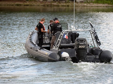 Members of the Sea Shepherd NGO looks for a beluga whale, which was spotted while swimming up France's Seine river, near a lock in Courcelles-sur-Seine, western France on August 5, 2022.