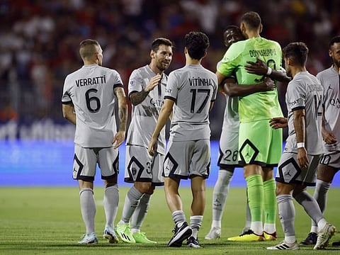Paris St Germain's Lionel Messi celebrates with Vitinha and Marco Verratti after the match.