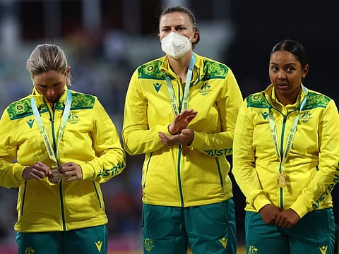 Gold medalists team Australia, including Australia's Tahlia McGrath (centre) wearing a face mask, stand on the podium during the medal ceremony for the women's Twenty20 Cricket on day ten of the Commonwealth Games at Edgbaston in Birmingham, central England.