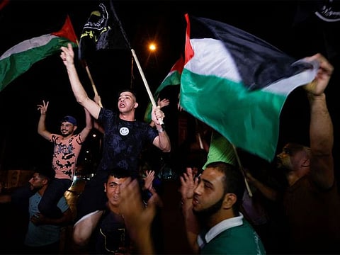  Palestinians celebrate on a street after a ceasefire was announced, in Gaza City August 8, 2022. 
