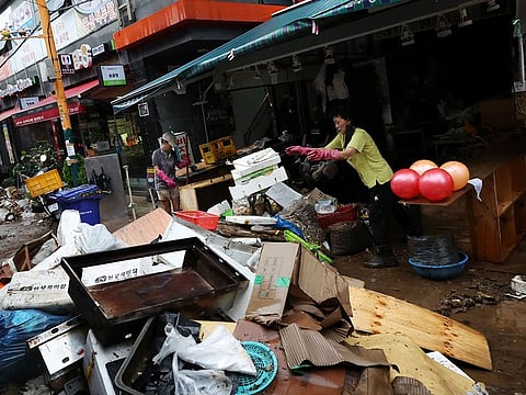  Han Kyoung-soo, a herbal medicine shop owner at a traditional market damaged by flood after torrential rain cleans up debris in Seoul, South Korea, August 9, 2022.