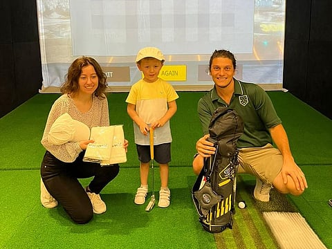 Four-year-old Finn Tilston with his US Kids Golf set of golf clubs prize, with PGA Professional Giovanni Losso (right) and Mirna Ghanem, Head of Marketing after winning his Division in the MyGolf Dubai US Kids Golf 'Free Junior Golfers Practice in August' initiative.