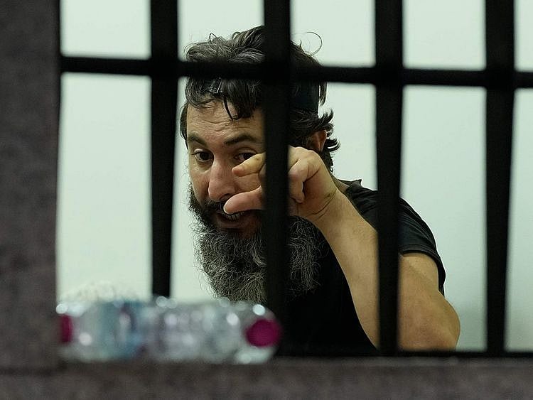 An armed man talks to hostages inside a bank in Beirut, Lebanon, on August 11, 2022.  