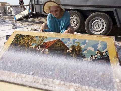 Multidisciplinary Israeli artist Sigalit Landau inspects one of her artworks, after being submerged in the salty Dead Sea water at the Ein Bokek resort.  