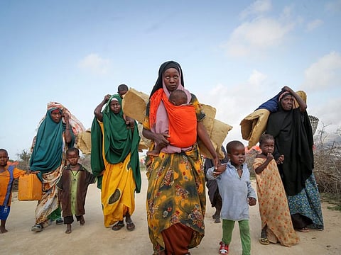 Somalis who fled drought-stricken areas carry their belongings as they arrive at a makeshift camp for the displaced on the outskirts of Mogadishu.