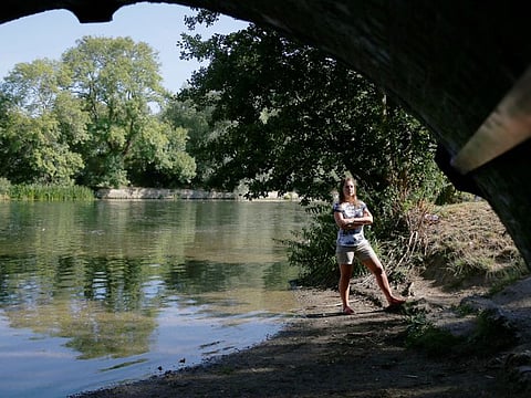Climate scientist, Professor Hannah Cloke, poses for a photograph on the banks of the River Thames in Sonning, Britain, August 10, 2022.
